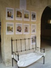 A bench against a wall with notices behind it