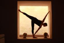 The silhouette of a person posing in a stretched position