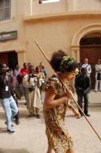 A woman with gold on her face walking down a street