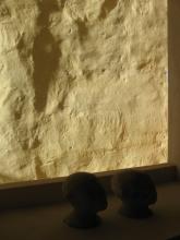 Sculptures of heads in front of a well lit wall