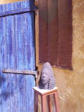 A statue of a head next to a blue door