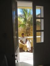 A woman sat in a chair by a palm tree